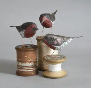 Paper robins sitting on cotton reels