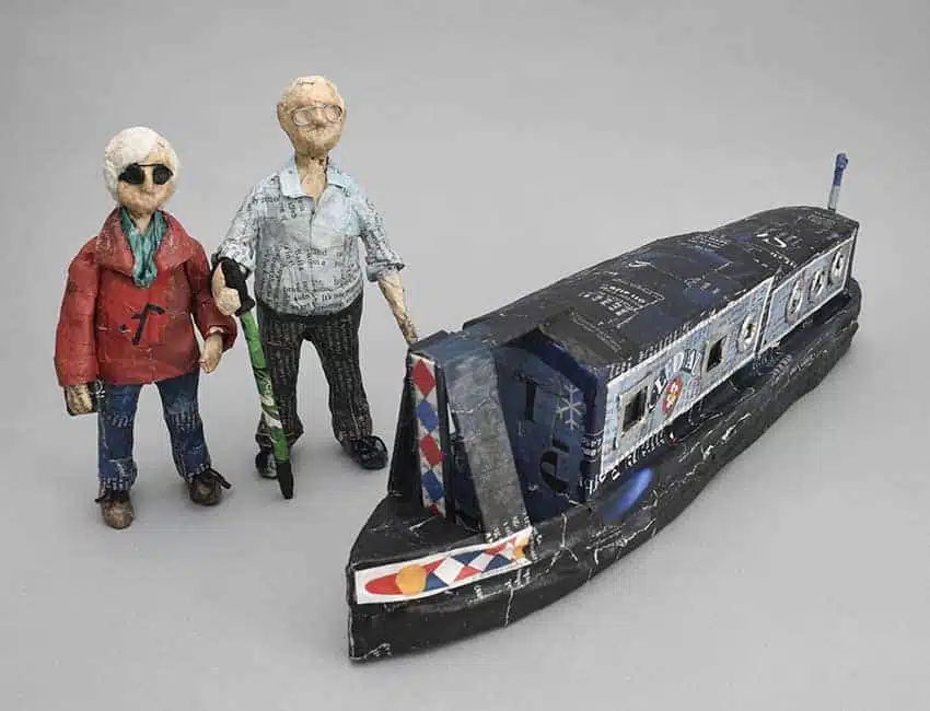 papier mache model of 2 figures with a boat