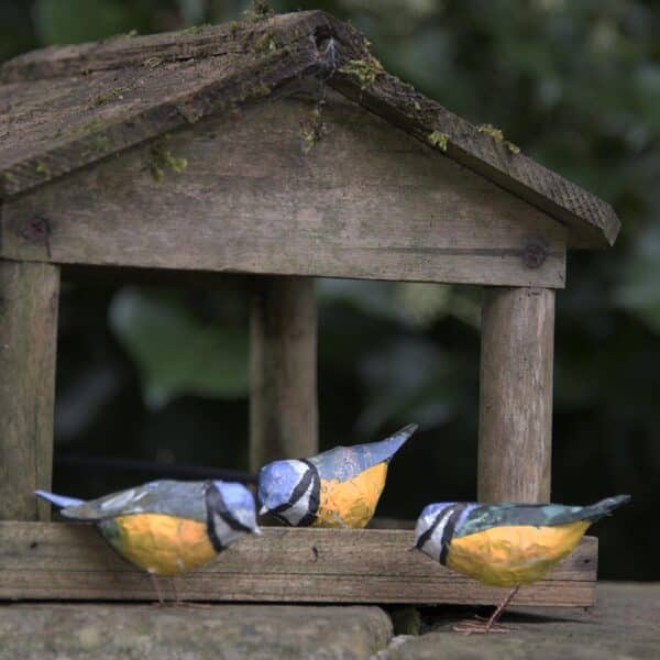 3 papier mâché blue tits in front of a bird house