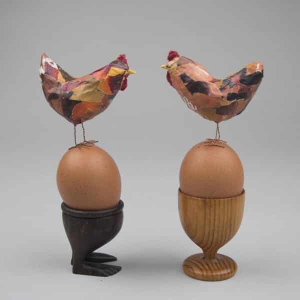 2 tiny chickens perched on egg cups