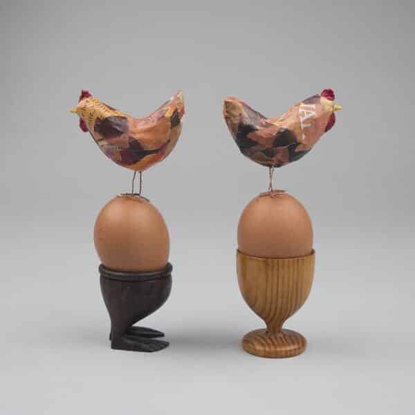 2 tiny chickens perched on egg cups