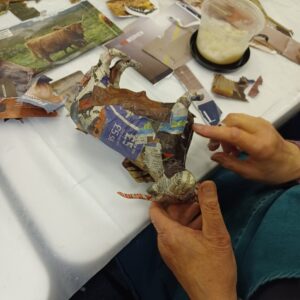 Person making a papier mache cow