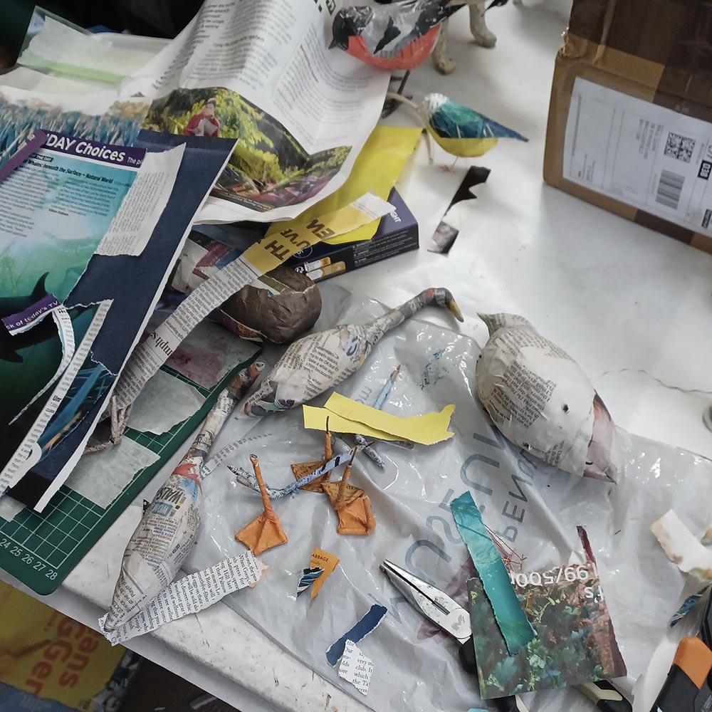 A table covered in equipment and materials for papier mache