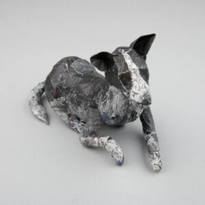 A papier mache model of a dog lying down
